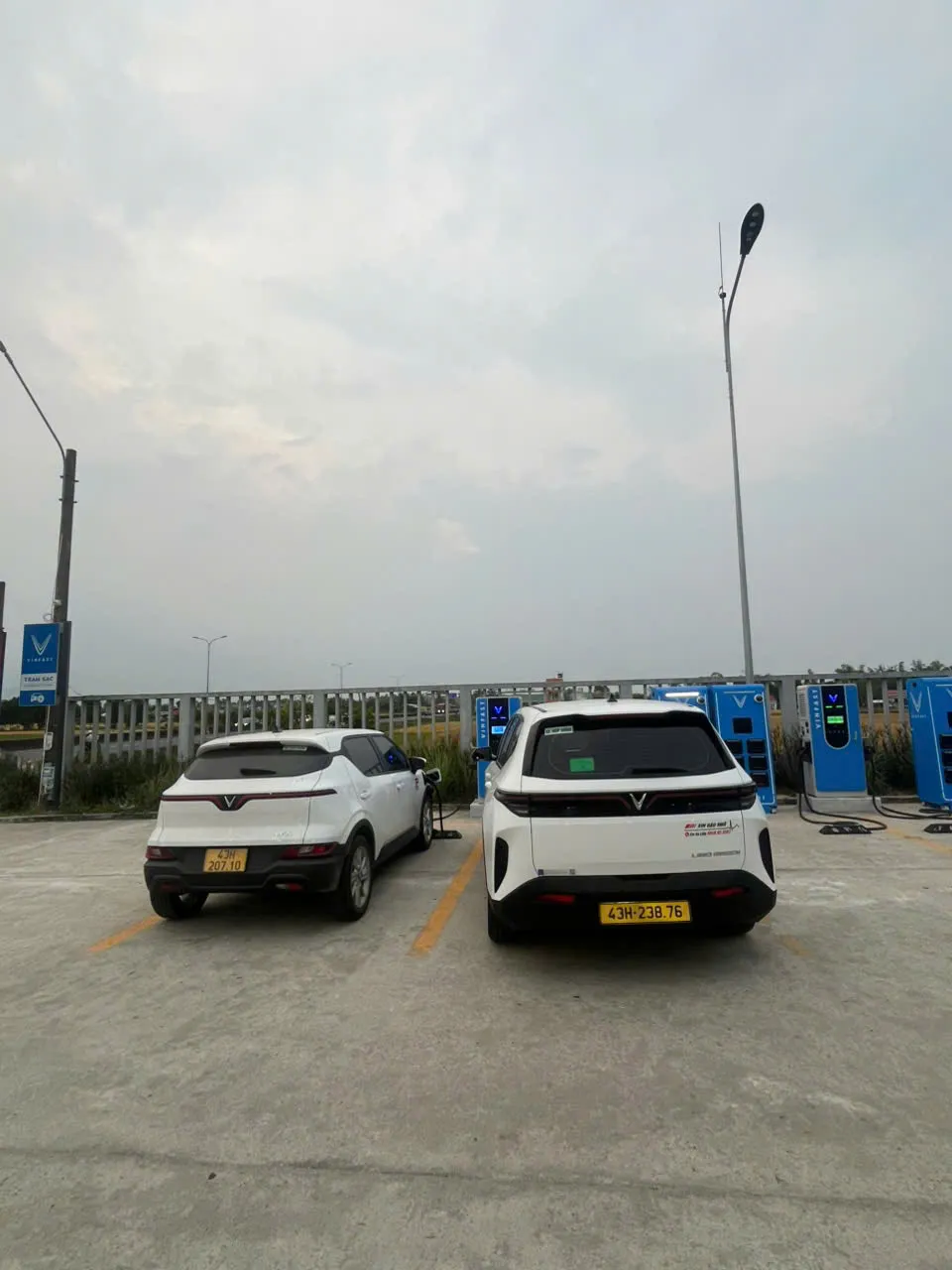 Hai xe điện VinFast màu trắng đang sạc tại trạm sạc